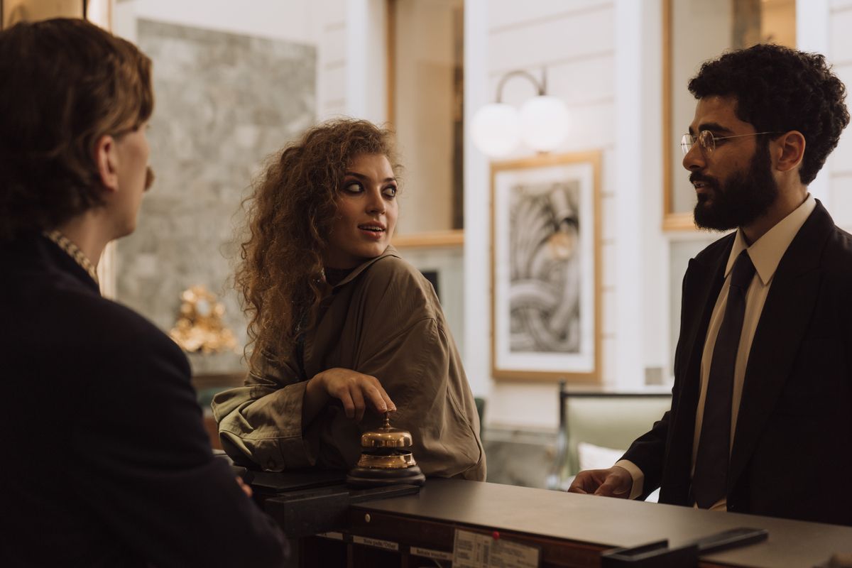 Guests checking in at a hotel reception desk, an example of a booking and appointment AI agent workflow