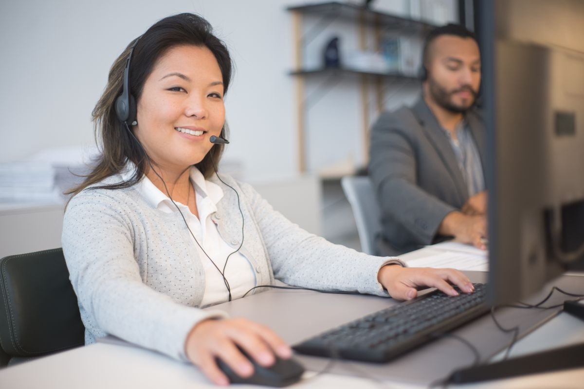 Customer support agent wearing a headset replying to enquiries, similar to how an AI customer support agent works