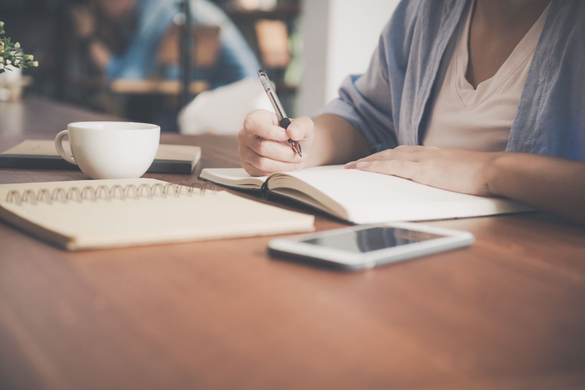 Business owner writing down customer leads and follow-up notes for lead management