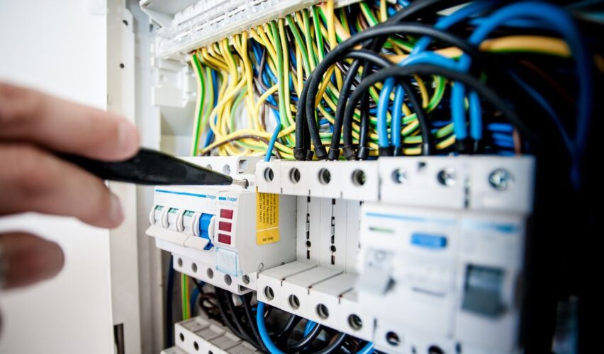 Electrician working on circuit breaker panel and wiring in Dehradun